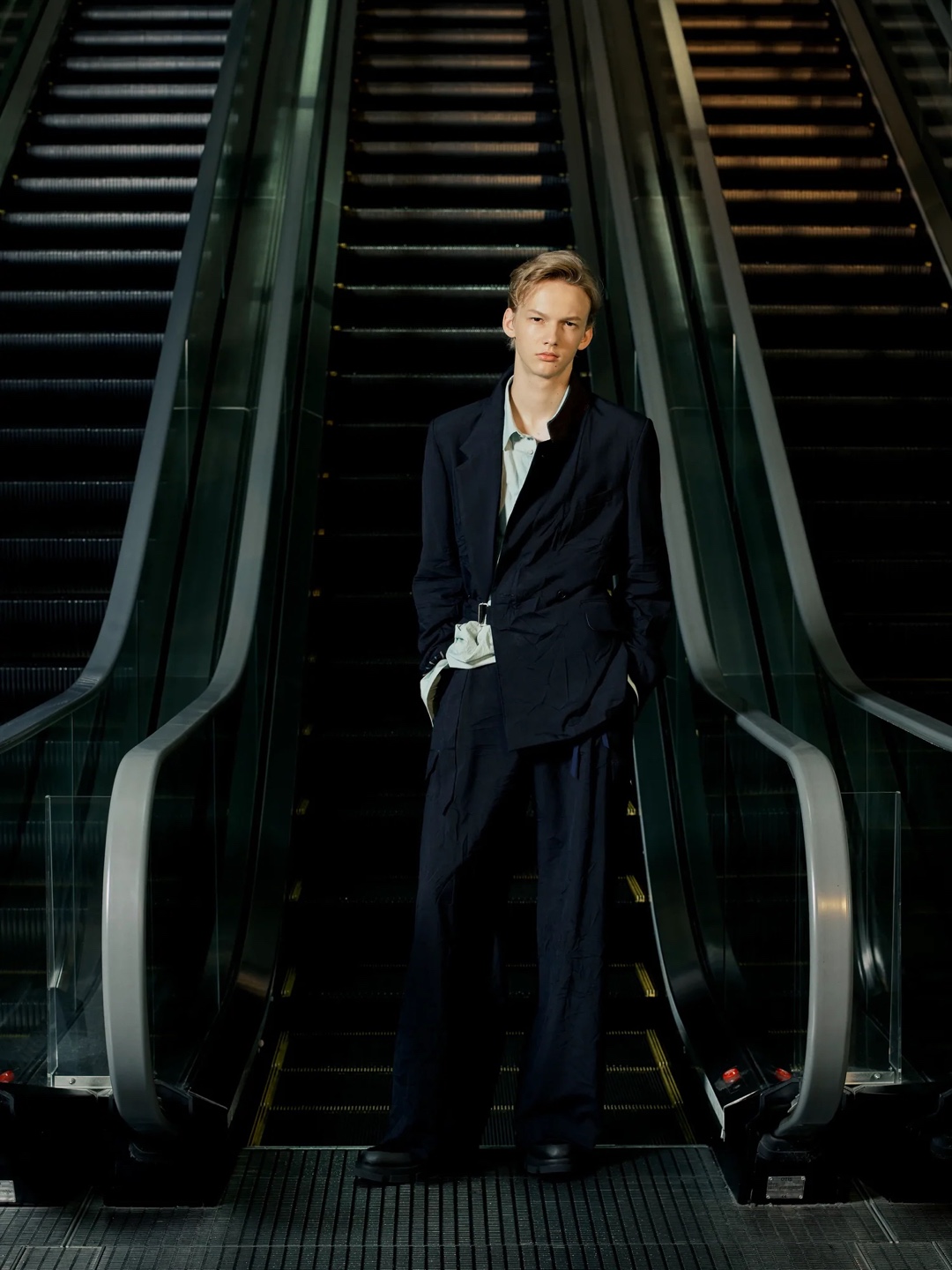 深蓝西装与阔腿裤保持成套感,前身斜向叠入一块有光泽的深色面板,Docking 的连接方式最直观。